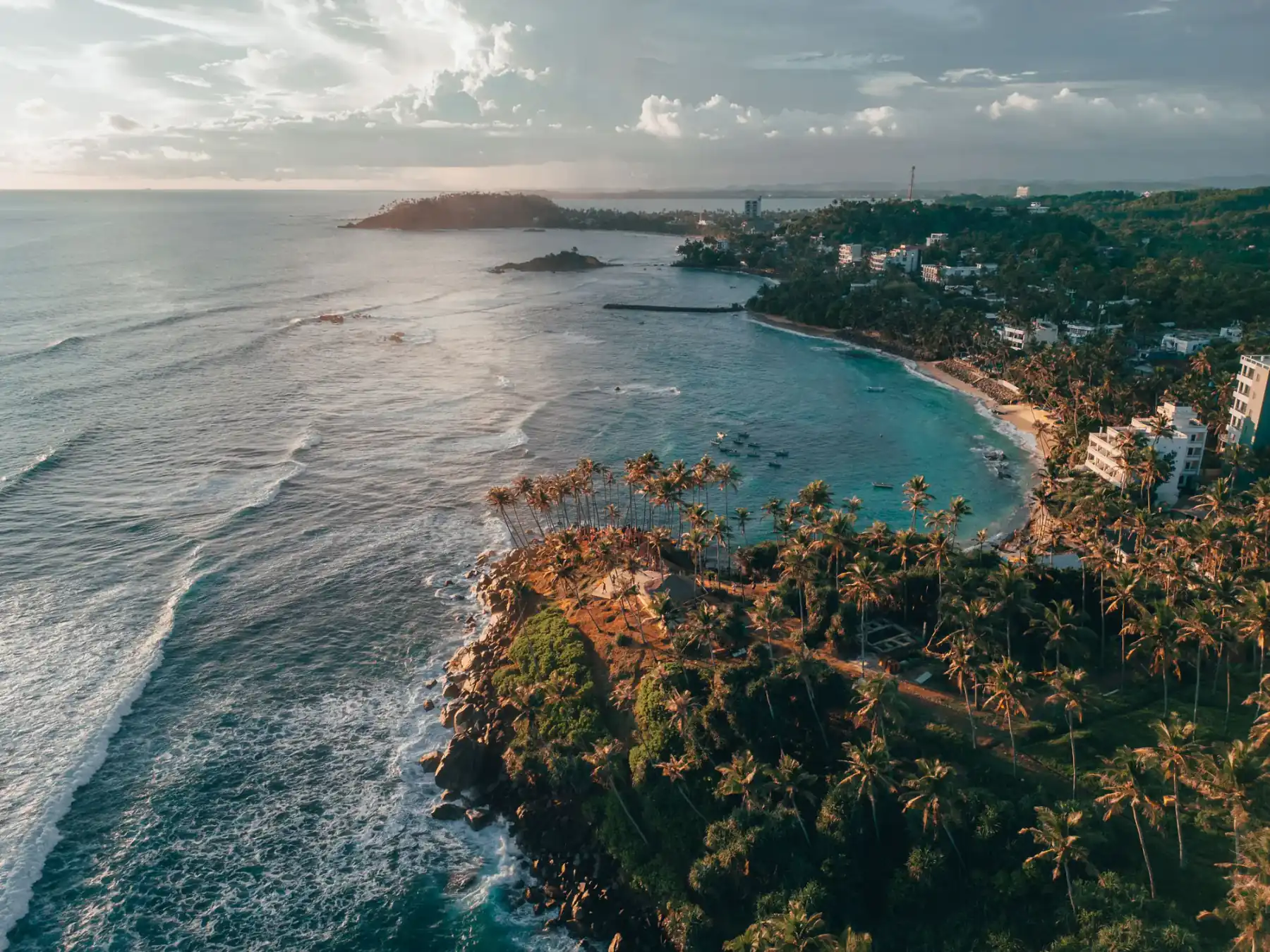 Sri Lanka's south coast: cliffs, breaking waves and palms at dusk.