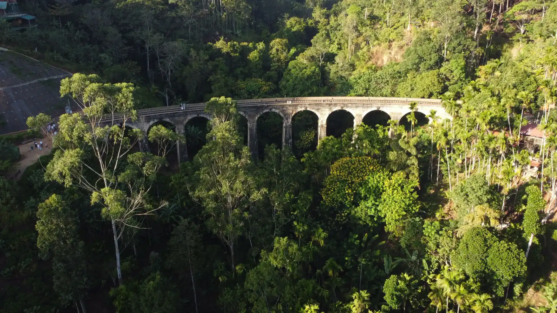 Aerial view of the Nine Arch Bridge threading through hill-country forest.