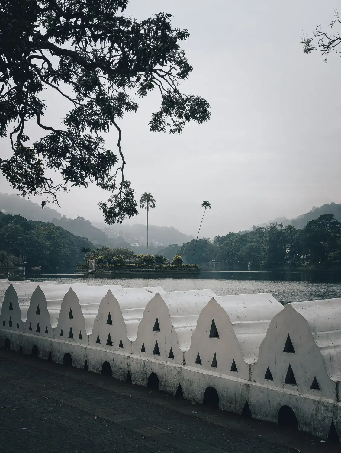 Kandy Lake with its small island pavilion, hills behind.